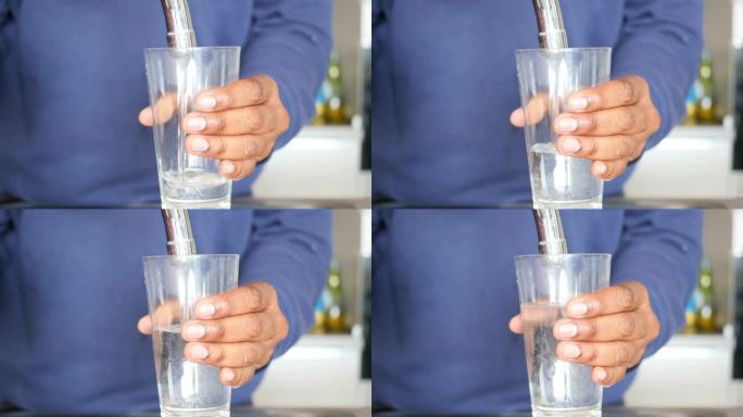 脏水从水龙头里从玻璃杯里流出，
