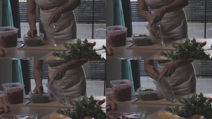 一名妇女在为冬天保存食物时将豌豆放入塑料冷冻袋中