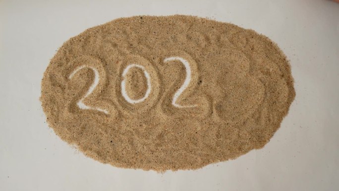 一只手把沙子上的数字3移走，代之以数字4，将2023年改为2024年。2023年至2024年新年变化