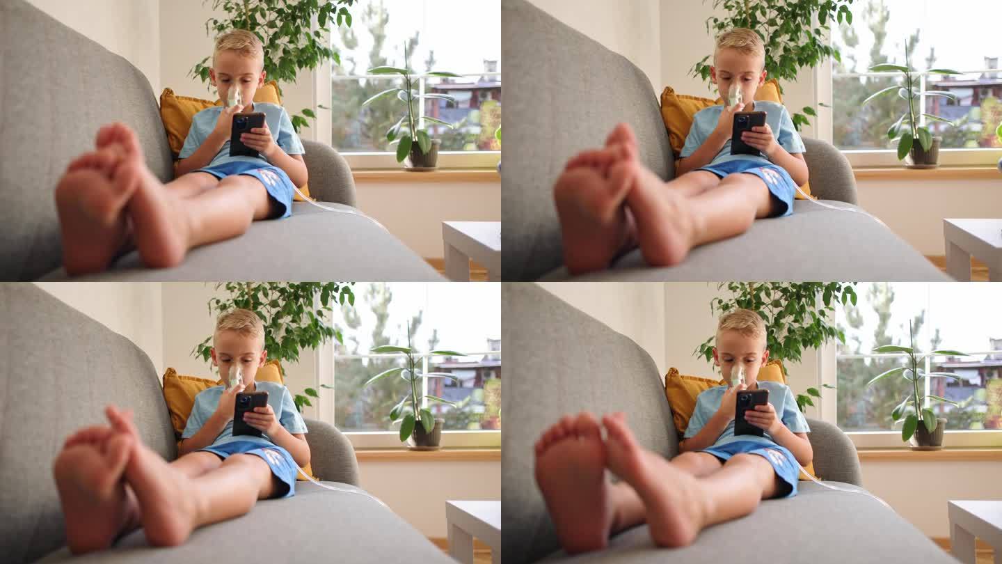患有哮喘的高加索男孩，在治疗期间，一边使用雾化口罩，一边坐在沙发上玩手机视频游戏