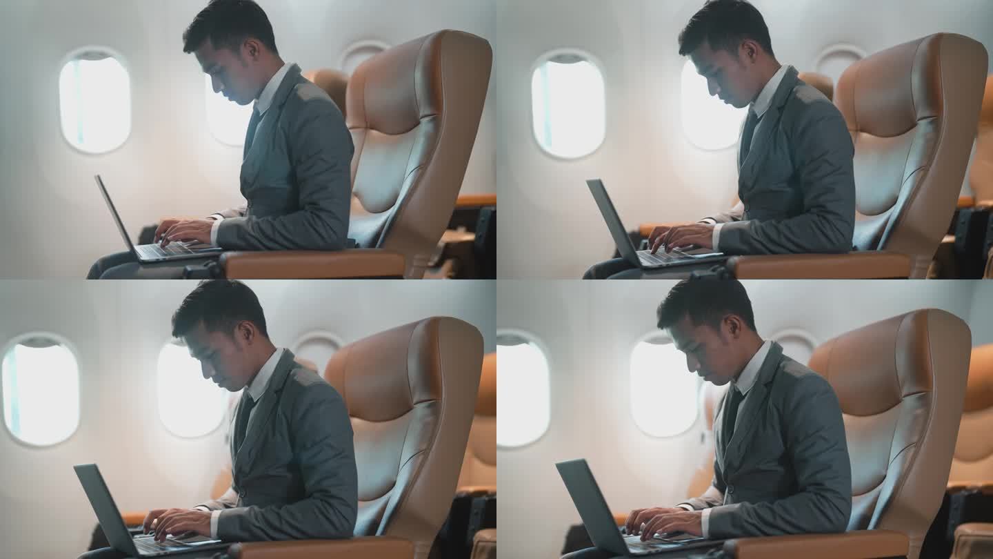 商务旅客乘飞机旅行时在笔记本电脑上工作。