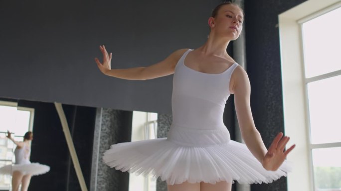 芭蕾舞女演员穿着尖头鞋和白色芭蕾舞裙踮着脚尖站立