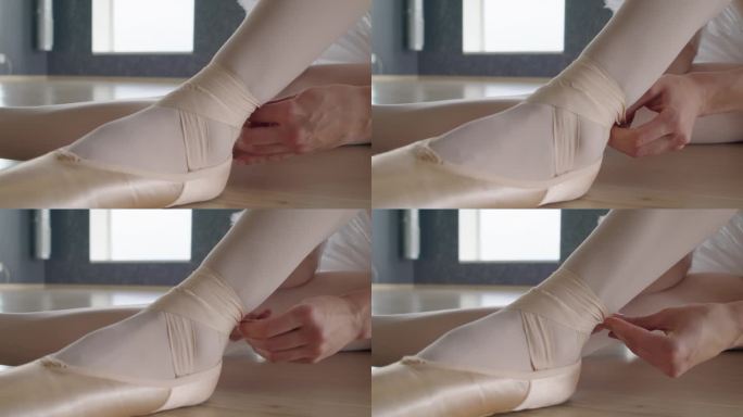 芭蕾舞女演员把缎带系在脚踝上，同时把脚尖放在脚上