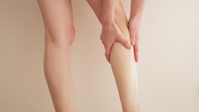 欧洲女人在家按摩她又细又长又累的腿。预防静脉曲张。