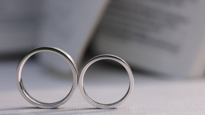 结婚婚礼戒指拍摄婚戒白色桌布书页翻动光影