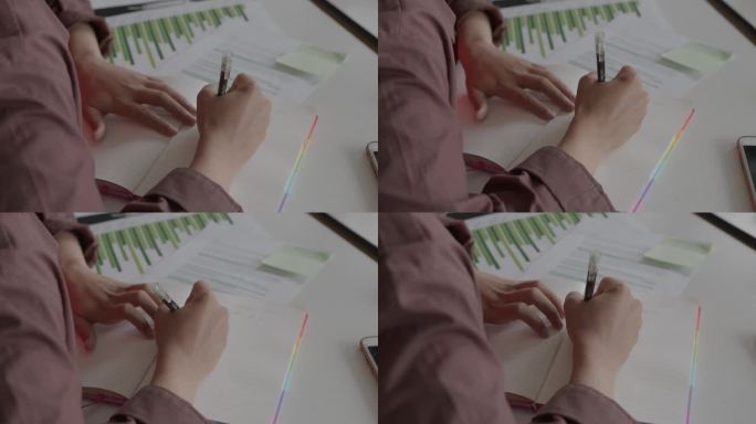 女大学生在教室里一边学习图表一边做笔记