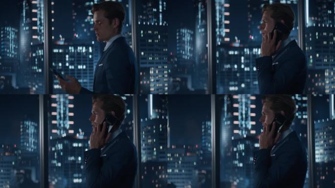 深夜，穿着时髦西装站在摩天大楼林立的大城市办公室窗边的英俊白人商人侧视图。男CEO用智能手机与客户交