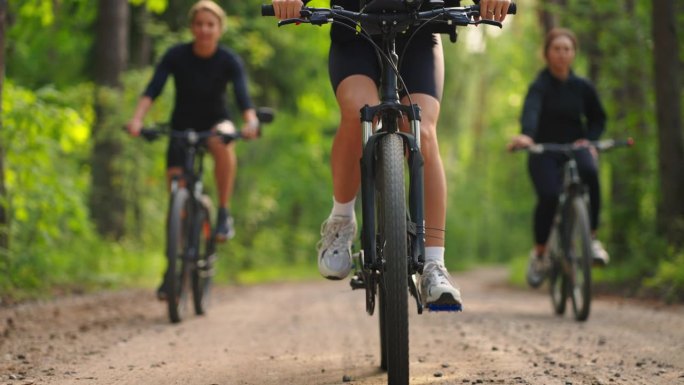 周末在大自然中积极休息，夏天在森林里骑自行车的妇女，车轮的细节视图