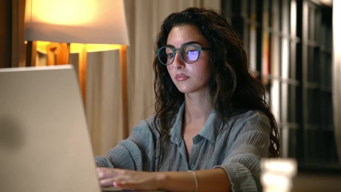 年轻女子在笔记本电脑上打字。室内企业企业家网络数字化在线学习。无线网络设备上的美女网络轻松远程工作