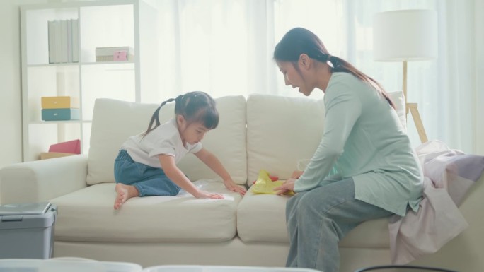 年轻的亚洲家庭妈妈教孩子如何回收帮助女孩折叠塑料袋意识到环境的重要性在家里的客厅。家庭幸福时刻。