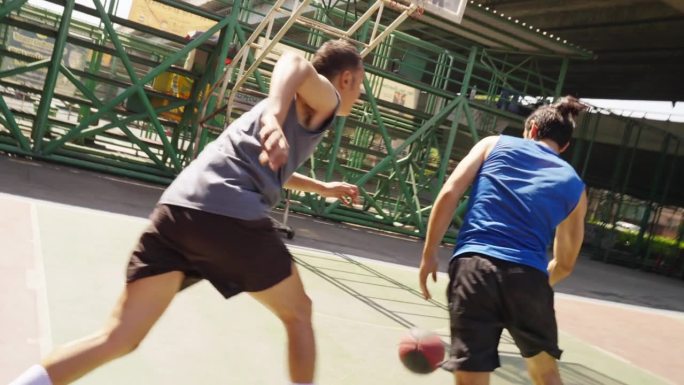 4K两个运动员在夏天阳光灿烂的日子里一起在室外球场打街球。