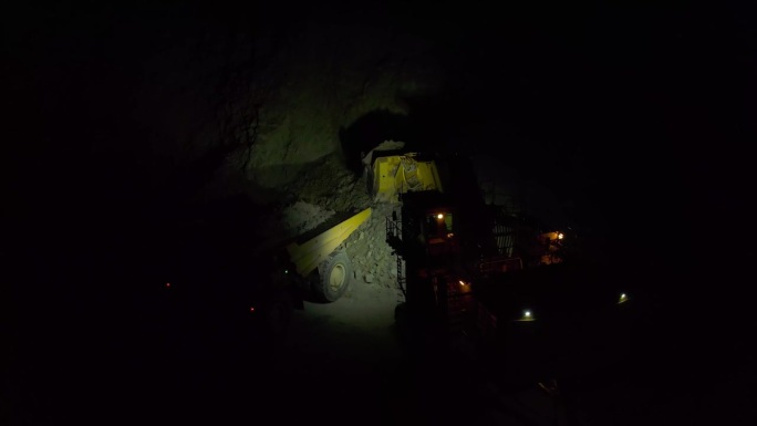 夜间挖掘机将矿石装入矿用自卸车的慢动作，慢动作
