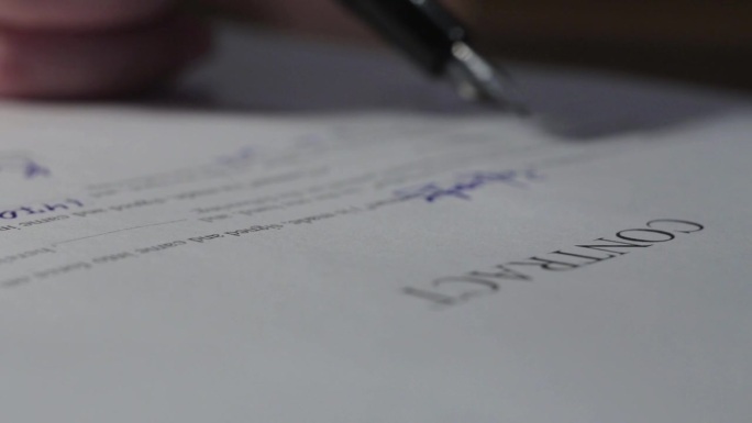 本合同由男性手写笔签字。在室内办公室工作中签署交易文件。撰写商业协议或签署公约议定书。通知或记录上客