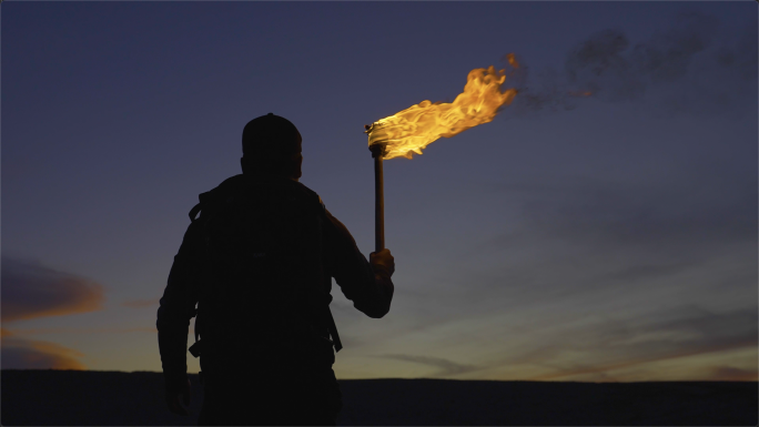 举着火把走路探险家黑夜里举着火把探索前行