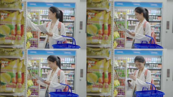 年轻的亚洲妇女在商店买零食和干果，她靠货架站着，看产品的细节。然后在货架上搜索所需商品，拿起并放入购