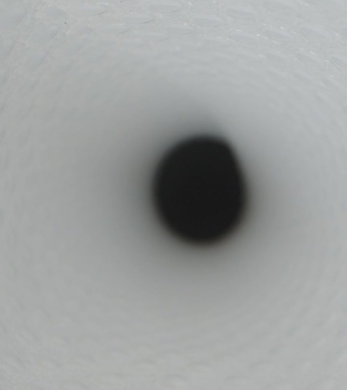 垂直视频。这是一个抽象的概念，相机在一个白色的隧道里，有快速移动的光束，一个超级高铁的概念。
