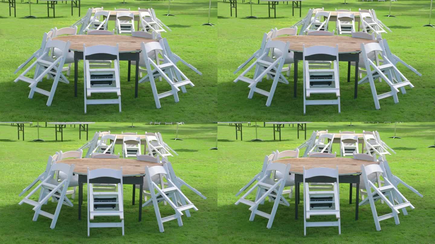 椅子围绕着花园草地上的圆桌，以4k慢动作60fps拍摄