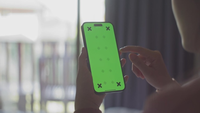 特写手女人使用绿色屏幕的智能手机