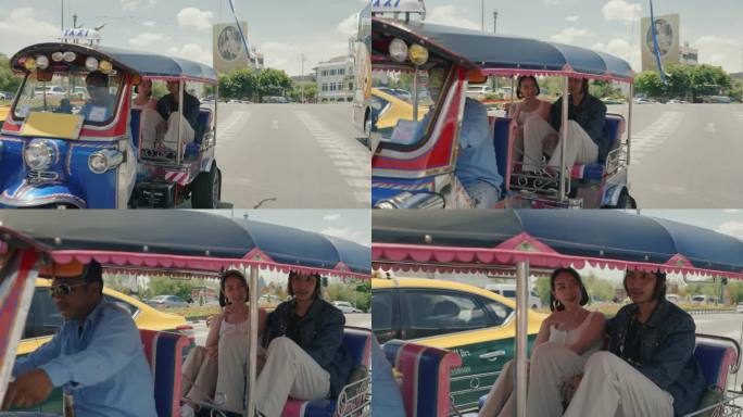 快乐的度假者:一对夫妇乘坐当地的嘟嘟车在曼谷的冒险。