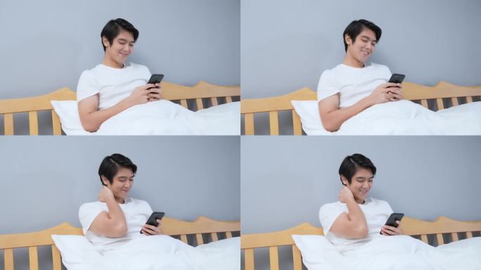 亚洲男子在卧室玩手机。