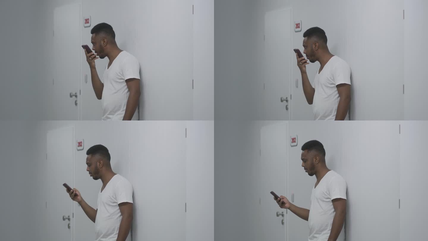 一名非裔美国男子在医院走廊用手机通话
