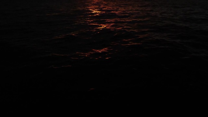 日落时，金色的阳光照在海面上，海水从柔和的水流中荡起涟漪