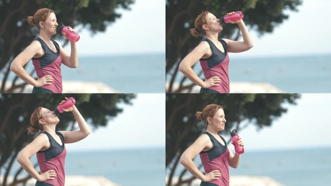 一个面带微笑、活泼、素颜的成年女子在户外用塑料瓶喝水