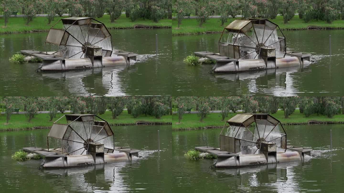 一个水轮机打包机在公园的池塘里运转。