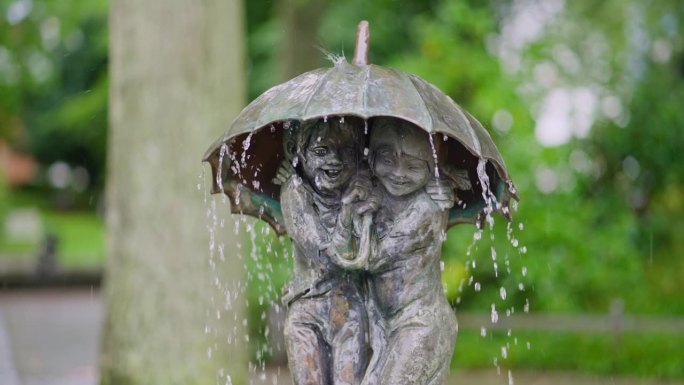宾茨镇，雕塑家弗里多·格拉齐亚尼(Frido Graziani)创作的伞下两个孩子的雕塑喷泉