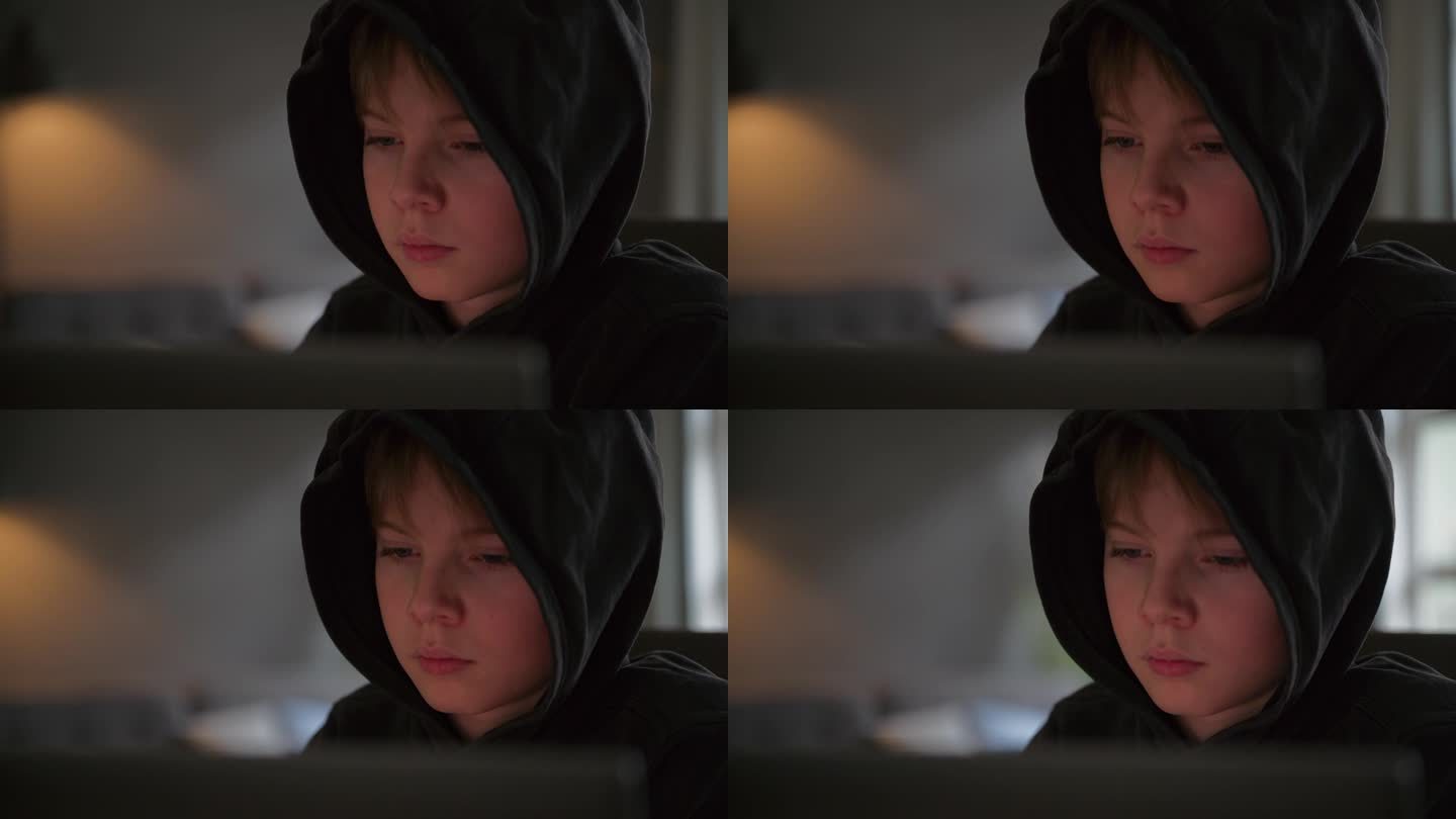穿着连帽衫的男孩坐在电脑前