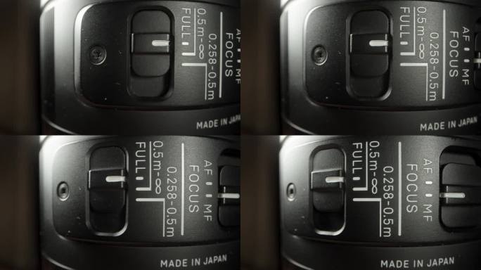 在特写镜头中旋转的相机镜头，有对焦开关和标签表明它是日本制造，特写镜头。
