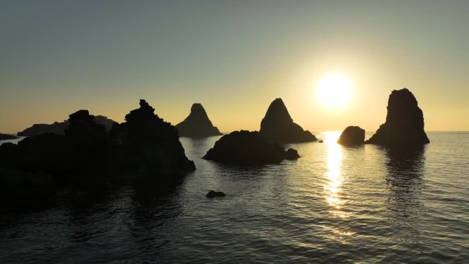 意大利西西里岛阿奇特雷扎前的岩石群岛上的日出。