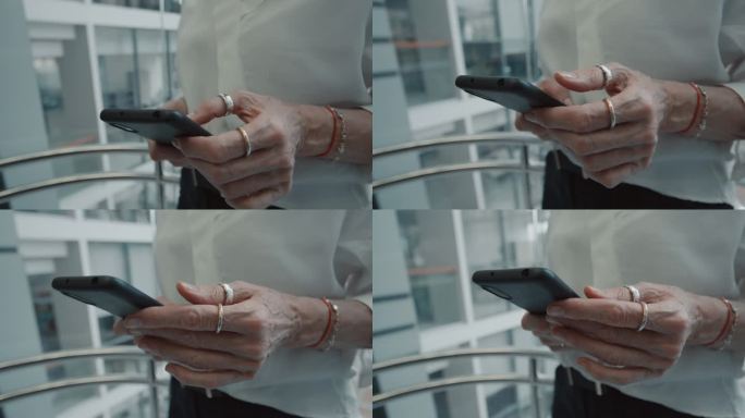 女白领在电梯里使用智能手机时的手