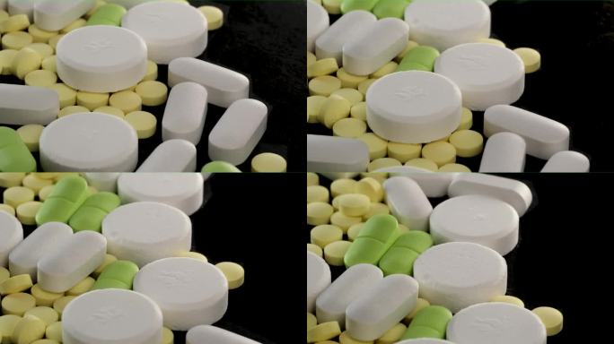 许多药物药丸不同的颜色，大小和形状在孤立的黑色背景。