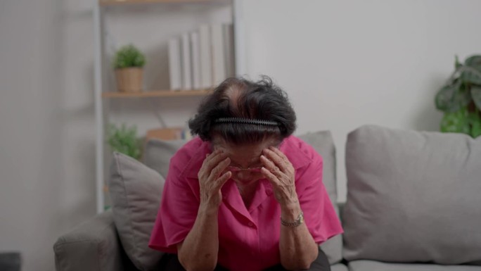 一位患有严重头痛的老年妇女患有中风，脑部疾病，病人用手抱着头，患有老年性痴呆，记忆力障碍，混淆老年痴