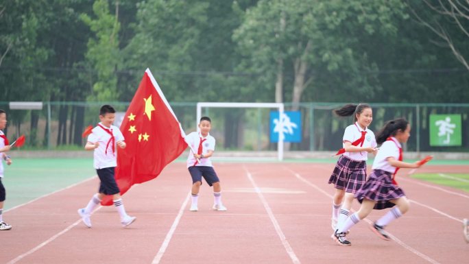 红领巾小学生挥舞国旗奔跑