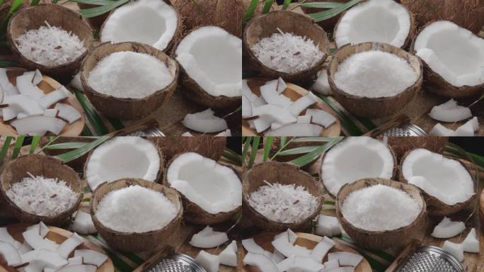 新鲜打开的椰子和椰子片、椰子片、椰子叶一起在木桌上慢慢旋转。