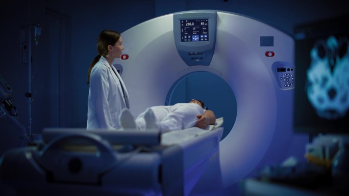 在医学实验室放射科医师控制MRI或CT或PET扫描的女性患者接受手术。高科技现代医疗设备。友好的医生