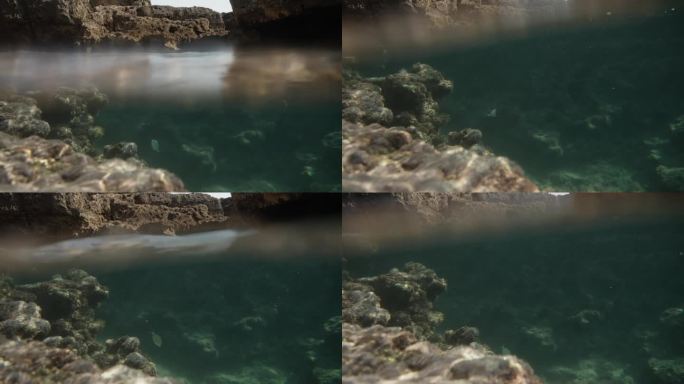 水下摄像机捕捉到了两个视角，海浪下面和海浪上面，悬崖边上有一条鱼。