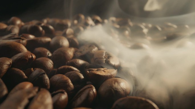 在黑背景下用烟熏咖啡豆。烟来自新鲜的咖啡籽。滑块微距拍摄，4K