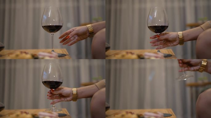 女性的双手优雅地举起酒杯敬酒，捕捉到品味一杯美酒的精致和享受。