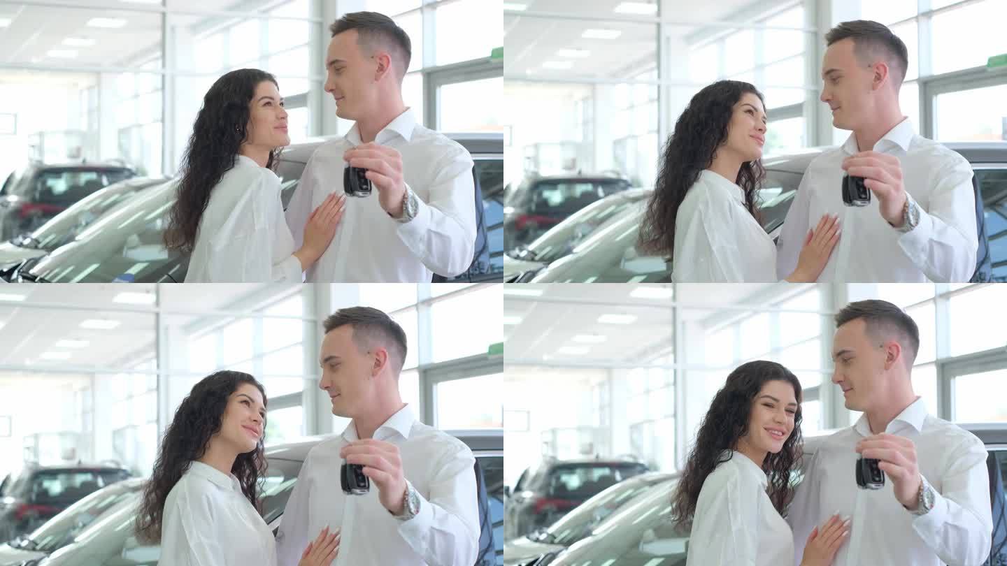 一对拥有新车的幸福夫妻。他们在一家汽车经销店出示钥匙。