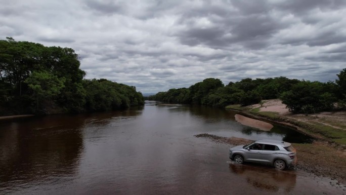 无人机拍摄的一辆汽车在巴西巴伊亚州查帕达迪亚曼蒂纳帕蒂河谷渡河的视频