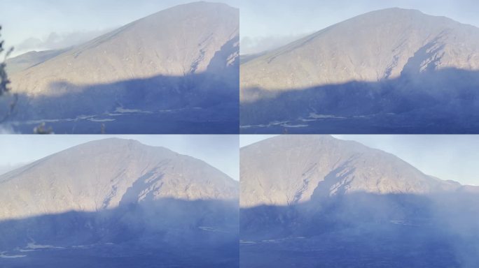 电影镜头从入侵的菠萝洋甘菊植物到夏威夷毛伊岛被云层覆盖的哈雷阿卡拉火山口。30fps的4K HDR