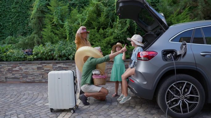 一家人给电动车充电，准备假日出游。