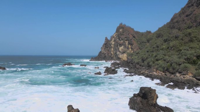 在印度尼西亚的岩石海岸上，海浪向后飞