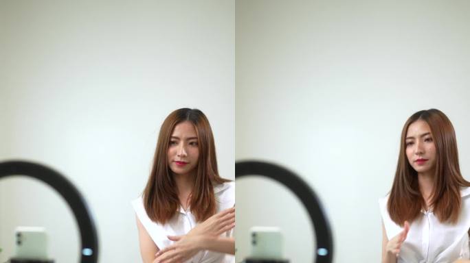 亚洲年轻女性网红在社交媒体上分享舞蹈内容和故事。博主拍摄了她在智能手机社交网络上跳舞的垂直视频。