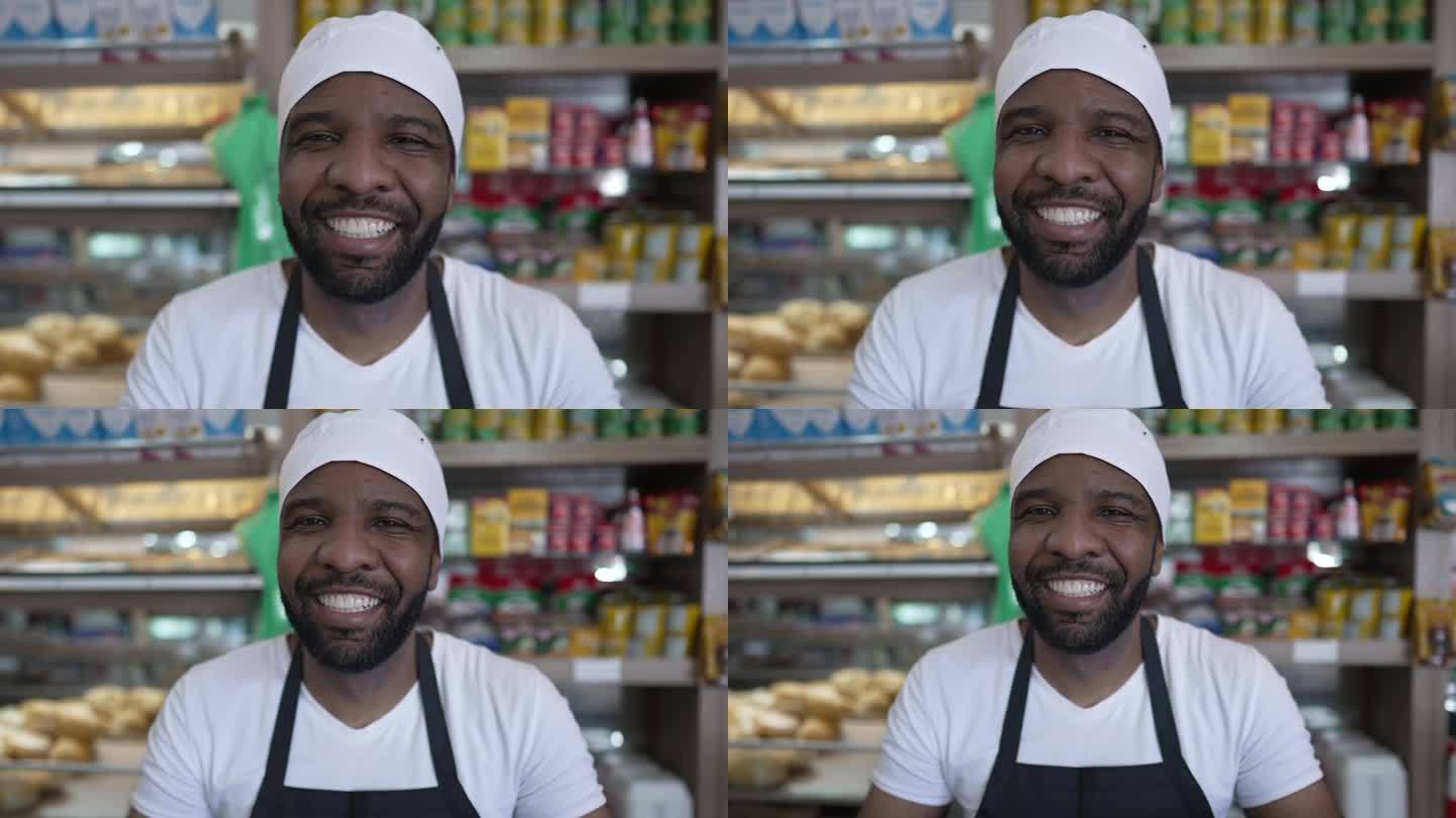 在自助餐厅柜台后面快乐的非裔美国工人，穿着制服，产品和消费品在背景中模糊，对着镜头微笑