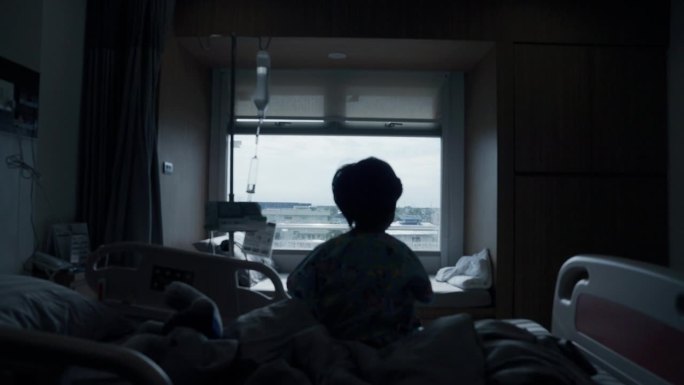 一个患流感的孩子的剪影，周末住院了。看着窗外。