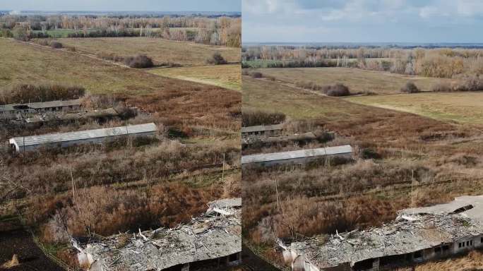 垂直航拍被摧毁的农场，有牛棚和有弹坑的谷仓，真实的乌克兰战争